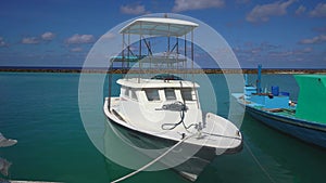 Sea harbor or port for the yacht club in the blue sea. Maldives. Docked ships and boats. Background for a travel blog or
