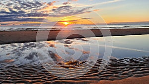 the sea, illuminated by the evening sun, recedes from the shore photo