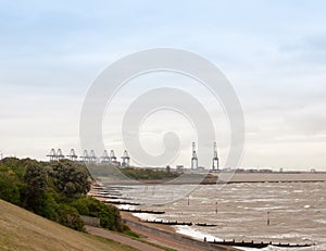 sea industry cargo and shipping cranes in the distance beach groynes Harwich Port