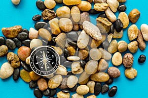 Sea journey, travelling and vacation concept. Compass on rocks and blue background top view