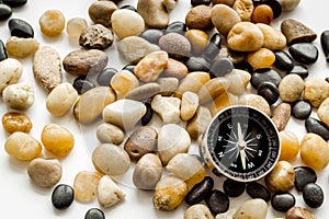 Sea journey, travelling and vacation concept. Compass on rocks and white background