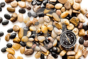 Sea journey, travelling and vacation concept. Compass on rocks and white background top view