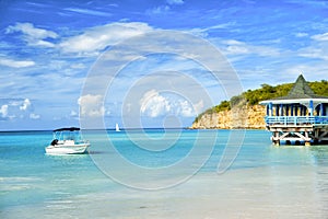 Sea lagoon with boat on blue water on cloudy sky