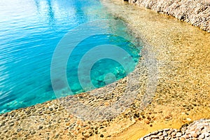 Sea lagoon with clear water. Shore is made of decorative stone