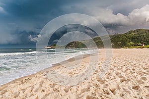 Sea landscape on beach with sunset light before an oncoming storm. Mole beach in Florianopolis