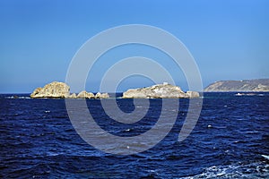 sea landscape and cliffs with a small solitary church near the island of Paros