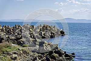 Sea landscape with concrete tetrapod breakwater stones piled up in wave breaker to protect