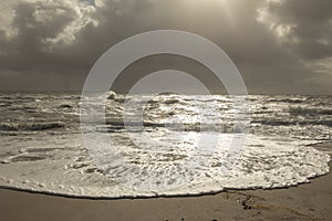 Sea landscape with huge waves and a lightbeam in Sylt