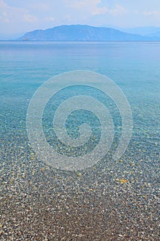 Sea landscape with pebbles and island in Turunc, Turunch Kumlubuk Mugla photo