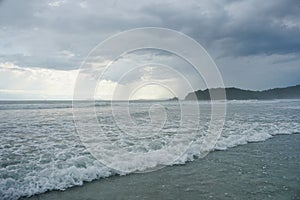 Sea landscape with rainy nimbostratus clouds and wave bubble dark water. Rainy weather with heavy clouds.