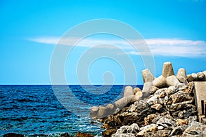 Sea landscape with rocks and concrete tetrapods for coastal protection from breakwaters