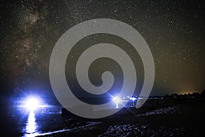 Sea landscape of the sandy beach and ocean with night divers against the background of the starry sky