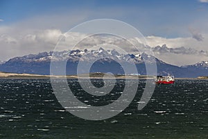 Sea landscape with a ship on great majestic snow mountains background. Beagle Channel, Ushuaia, Argentina