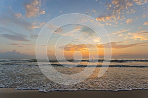 The sea is lapping the sand beach in evening sunset. Blue orange sky with sea view background