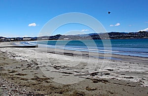 The sea laps gently on the sandy beach at Lyall Bay near Wellington in New Zealand