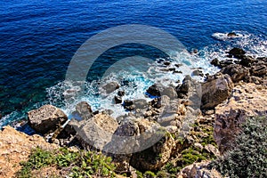 The sea laps over rocks on the Mediterranean island of Malta