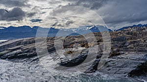 Sea lions are resting on the rocky slope of the island in the Beagle Channel.