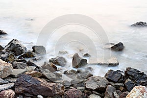 Sea mist softness of the tides and sunset at evening with rocks