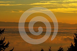 Sea and mountains with thick fog at sunset