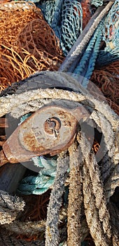 Sea net and rig, rustic sea fishing equipment.  old rope and colored fishing net. fishing ship details. Detail of the machinery of