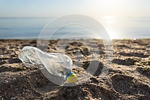 Plastic Bottle Lying On Beach Near Water, Sea Pollution Background