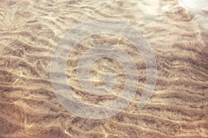 Sea ocean sand ground with waves ripples. Clear clean shallow water on sandy beach