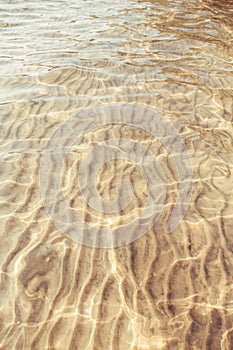 Sea ocean sand ground with waves ripples. Clear clean shallow water on sandy beach