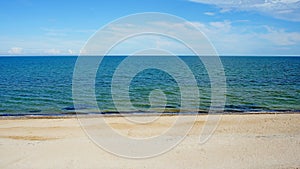 Sea. ocean. sea surface. almost calm. deserted beach. horizon line. dark blue water, clean sandy beach and light clouds in the sky