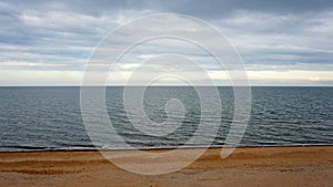 sea. ocean. sea surface. almost calm. horizon line. dark blue water  sandy beach and cloudy sky