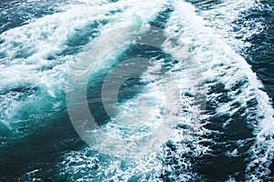 Sea or ocean waves surface texture. Abstract summer blue water background with splashes of sea foam.