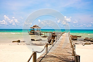 Sea with pier under blue cloudy sky