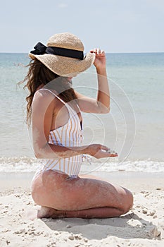 Sea pinup style. Woman on summer vacation at beach. Summer vacation of woman in swimsuit and straw hat. Retro woman at sea beach.