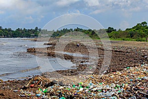 Sea Pollution: Garbage dumped in the Sri Lankan Sea near Colombo. women collects plastic things in a pile of garbage brought by