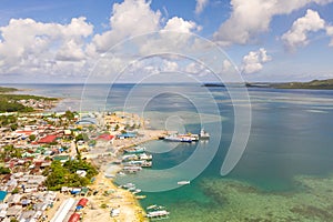 Sea port in the city of Dapa, Philippines. Fishing village and ships, view from above.