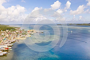 Sea port in the city of Dapa, Philippines. Fishing village and ships, view from above.