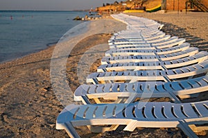 Sea resort with empty white sun loungers. sunrise on the beach