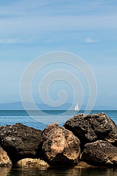 Sea and rock background. Rock and blue sea with clear sky. Seaside travel destination background image. Clear blue sea and blue