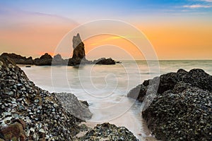 Sea rock over seacoast with beautiful sunset sky