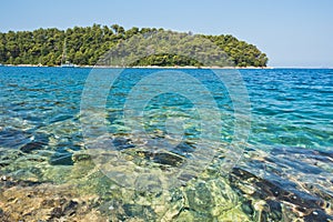 Sea rocks below surface of crystal clear turquoise water at morning in Panormos bay, island of Skopelos