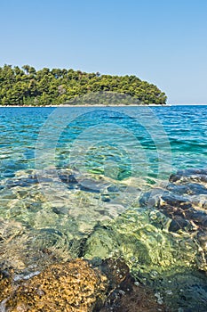 Sea rocks below surface of crystal clear turquoise water at morning in Panormos bay, island of Skopelos