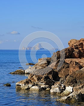 Sea, rocks and Ibiza in the background photo