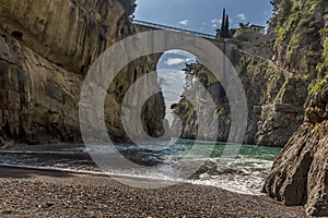 The sea rounds the corner in the Fiordo di Furore on the Amalfi coast, Italy and gently breaks on the shingle beach photo
