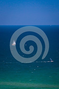 Sea with sailing ships and windsurfers