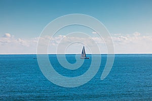 Sea and sailing wind boat. Sailboat over blue waves and sunny sky