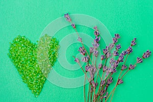 Sea salt for bath and relaxation poured in heart shape and dried herbarium of lavender flowers with selective focus