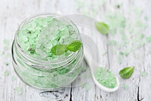 Sea salt bath scented mint for spa and aromatherapy on white wooden background