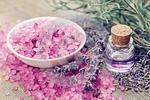 Sea salt, bottle of essential oil and lavender flowers.