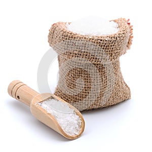 Sea salt in burlap sack bag with wooden scoop isolated on white background