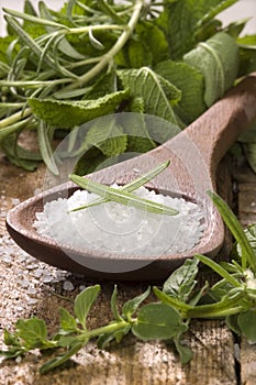 Sea salt with herbs in a wooden spoon