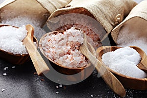 Sea salt and himalayan on spoon. Crystals of salt on background